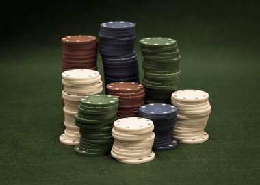 yeşil zemin üzerine poker fişleri yığını