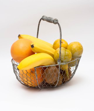 Beyaz zemin üzerinde bir sepet meyve