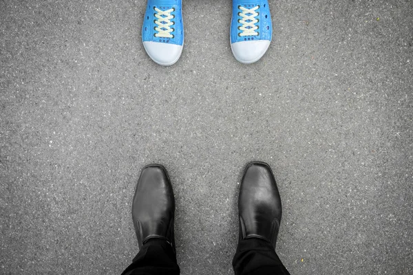 Zwarte schoenen staan tegenover blauwe schoenen — Stockfoto