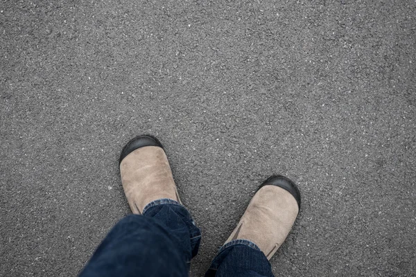 Zapatos marrones de pie sobre el suelo de hormigón asfaltado —  Fotos de Stock