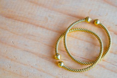 Ahşap masa üzerinde altın bilezik