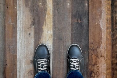 Ahşap zemin üzerinde duran siyah casual Ayakkabı