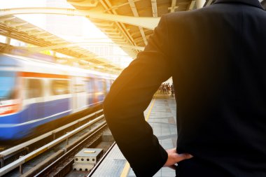 bir tren bekleyen iş adamı