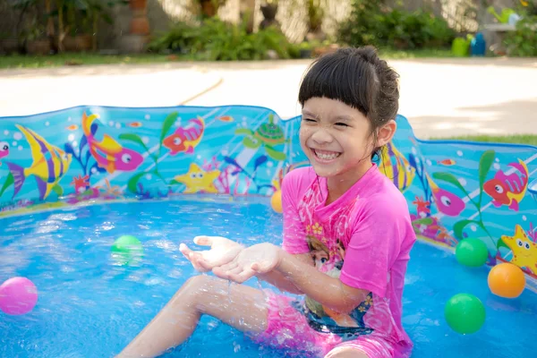 Baby girl playing in kiddie pool — Stock Photo, Image