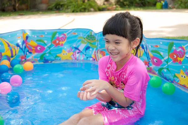 Baby girl playing in kiddie pool — Stock Photo, Image