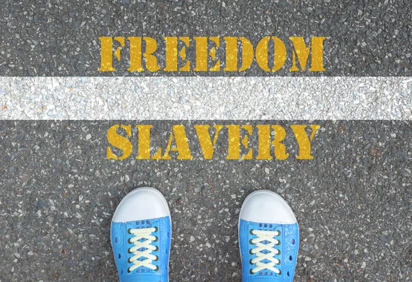 Shoes standing at the line between slavery and freedom — Stock Photo, Image