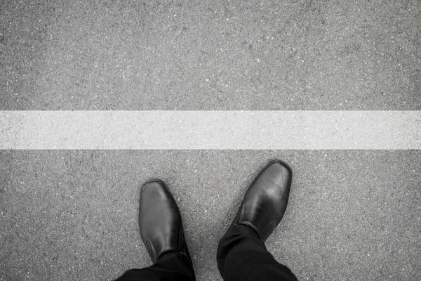 Μαύρα παπούτσια στέκεται μπροστά από την λευκή γραμμή — Φωτογραφία Αρχείου