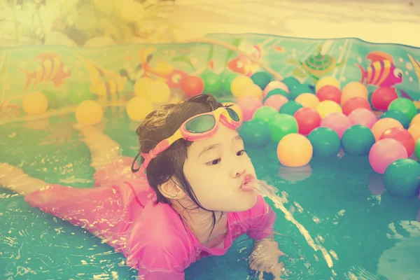 Baby girl playing in kiddie pool - vintage effect — Stock Photo, Image