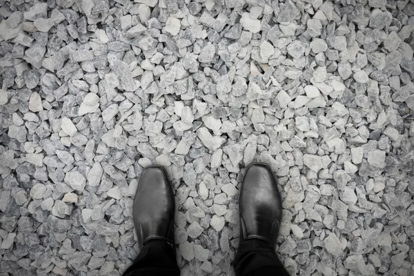 Zapatos negros sobre piedras — Foto de Stock