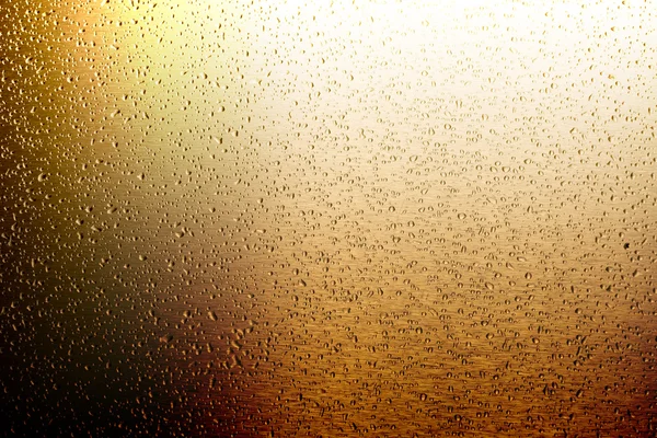 ゴールドの金属表面上の水滴 — ストック写真