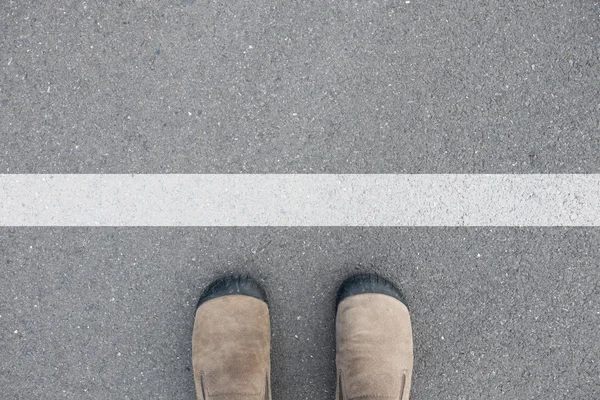 Shoes standing at the white line — Stock Photo, Image
