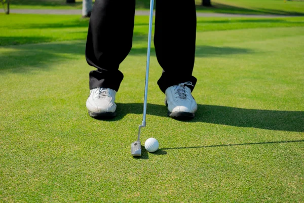 Golfer putting golf ball