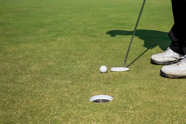 Golfista colocando bola de golfe — Fotografia de Stock