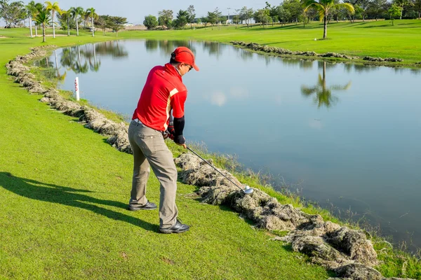 Golfeur essayer de jouer la balle sur l'herbe coupée — Photo