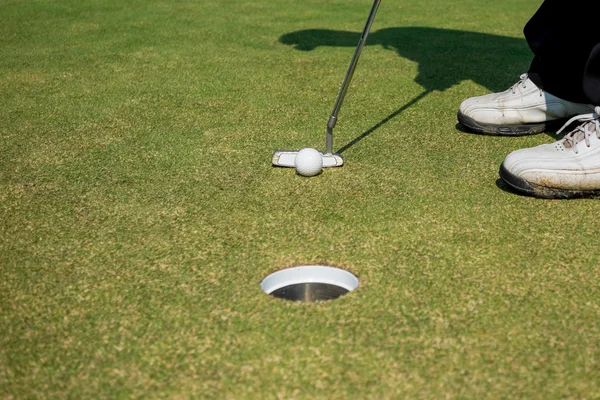 Golfista colocando bola de golfe — Fotografia de Stock