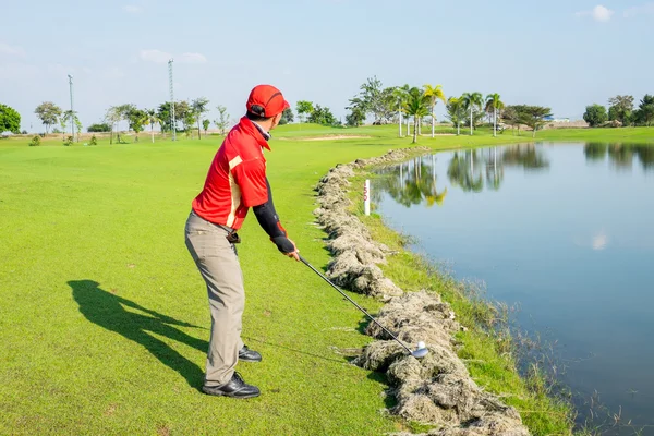 Golfeur essayer de jouer la balle sur l'herbe coupée — Photo