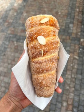 Elinde şeker ve badem gevreğiyle baca keki tutuyordu.