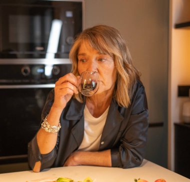 Son sınıf öğrencisi kadın kahve içiyor. Düşünceli, düşünceli ve evinde dinleniyor.