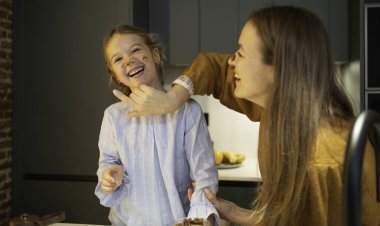 Anne ve kızı mutfaktaki pişirme etkinliği sırasında kaynaşıyorlar.