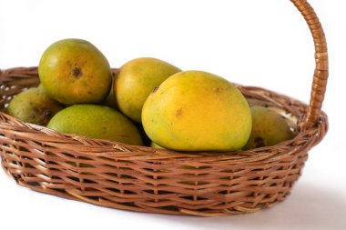 Beyaz bir arka planda sepetteki Hint mangoları.