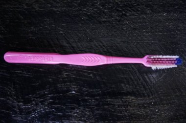 Siyah ahşap çerçevede pembe diş fırçası