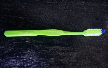 Siyah ahşap çerçevede yeşil diş fırçası