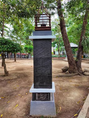 Siyah bir anıtın üzerinde bir bahçe lambası.