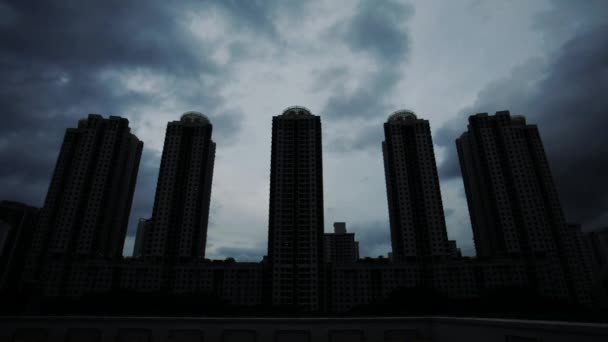 Čas-lapse bytových domů v zamračeném večeru, jak padá noc, Singapur