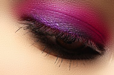 Beautiful macro shot of female eye with creative makeup. Bright colorful makeup. Cosmetics and make-up. Closeup macro shot of fashion sparcle visage