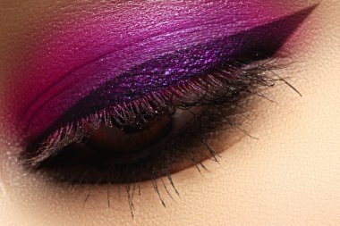 Beautiful macro shot of female eye with creative makeup. Bright colorful makeup. Cosmetics and make-up. Closeup macro shot of fashion sparcle visage