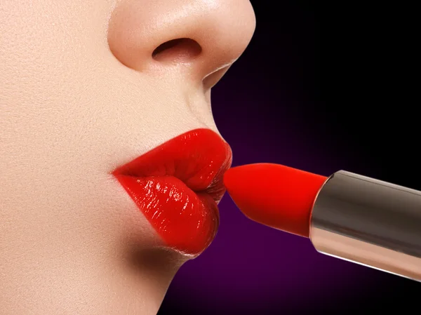 Extrême gros plan sur le modèle appliquant rouge à lèvres rouge. Maquillage. Maquillage professionnel rétro mode. Rouge à lèvres rouge — Photo