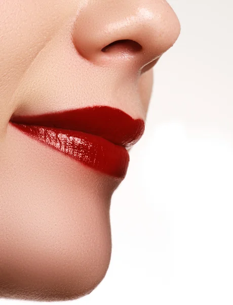 Primo piano di labbra femminili con trucco lucente. Macro della faccia di donna. Trucco labbra moda con rossetto rosso — Foto Stock