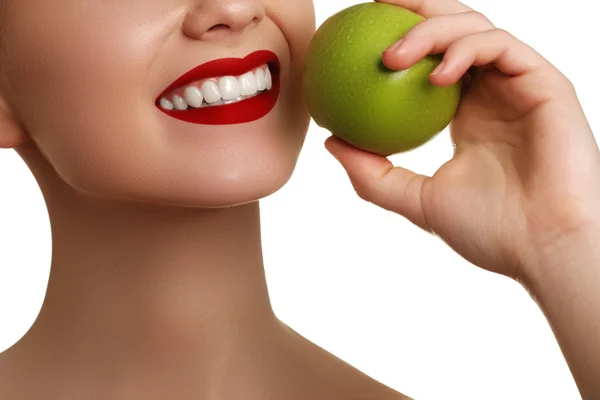 Primer plano de la cara de una mujer comiendo una manzana verde, aislada sobre fondo blanco. Hermosa cara de mujer adulta joven con piel limpia y fresca — Foto de Stock