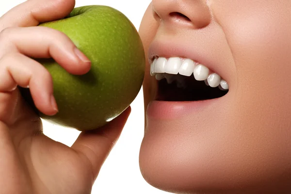 Closeup of the face of a woman eating a green apple, isolated against white background. Beautiful face of young adult woman with clean fresh skin — Stock Photo, Image