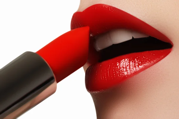 Extrême gros plan sur le modèle appliquant rouge à lèvres rouge. Maquillage. Maquillage professionnel rétro mode. Rouge à lèvres rouge — Photo
