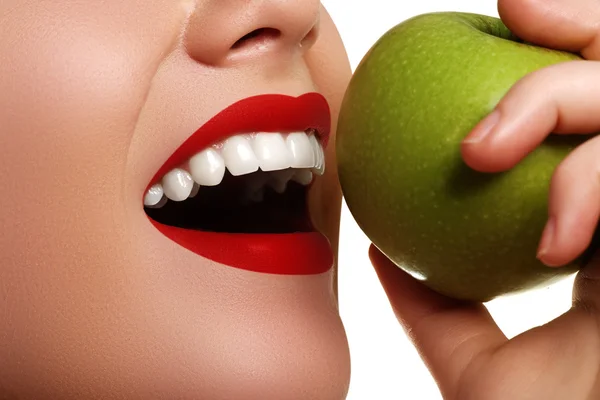 Closeup of the face of a woman eating a green apple, isolated against white background. Beautiful face of young adult woman with clean fresh skin — Stock Photo, Image