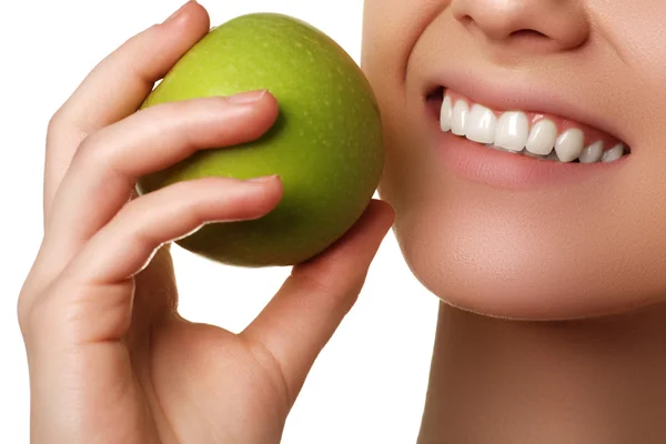 Zbliżenie twarzy kobiety jedzenia zielone jabłko, izolowane na białym tle. Piękna twarz młodej dorosłej kobiety z czystą świeżą skórą — Zdjęcie stockowe