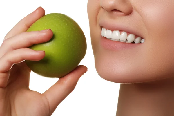 Крупный план лица женщины, поедающей зеленое яблоко, изолированное на белом фоне. Красивое лицо молодой взрослой женщины с чистой кожей — стоковое фото