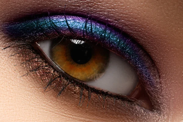 Hermoso macroplano de ojo femenino con maquillaje creativo. Maquillaje colorido brillante. Cosméticos y maquillaje. Primer plano macro disparo de la moda sparcle visage — Foto de Stock