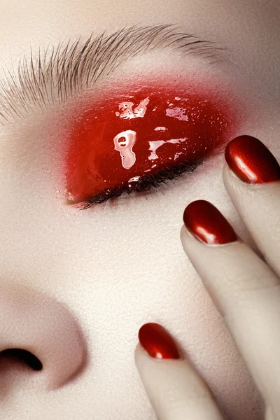 Mooie vrouwelijke vinger nagels met rode nagel close-up op bloembladeren. perfecte manicure — Stockfoto