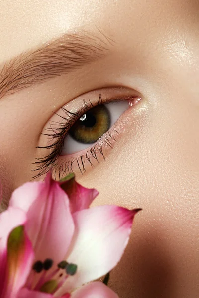 Gorgeous young model, beautiful woman eye with fresh pink  flower, part of female head, sexy girl with stylish look, spa and beauty background — Stock Photo, Image