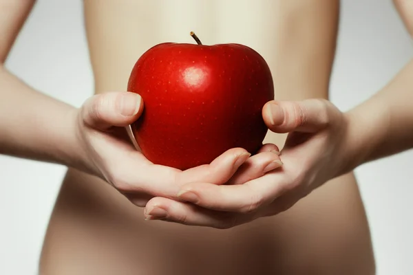 Manos sosteniendo manzana roja. Retrato de una mujer joven sosteniendo manzana roja en su mano — Foto de Stock