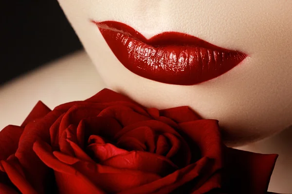 Primer plano de los labios de la mujer sexy con lápiz labial de color rojo oscuro y hermosa rosa roja —  Fotos de Stock