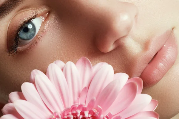 Beauty face of the young beautiful woman with flower — Stock Photo, Image