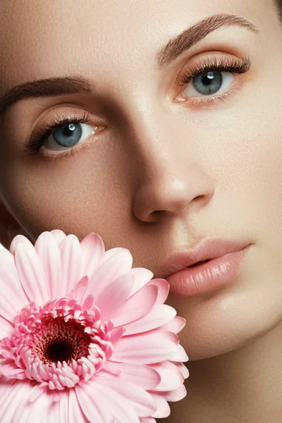 Beauty face of the young beautiful woman with flower — Stock Photo, Image