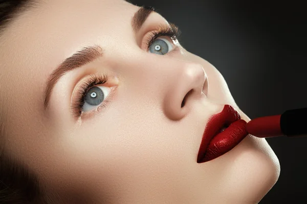 뷰티 입술. 아름다운 입술 클로즈업, 화장품의 광고에 대한 좋은 아이디어. 레드 립스틱을 적용하는 모델. 메이크업. 전문 패션 복고풍 메이크업입니다. 레드 립스틱 — 스톡 사진