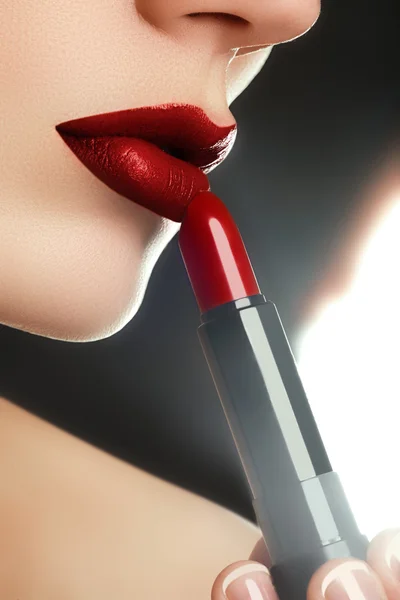 Skönhet läppar. Beautiful lips närbild, bra idé för reklam för kosmetika. Extrem närbild på modell tillämpa rött läppstift. Makeup. Professionell mode retro make-up. Rött läppstift — Stockfoto