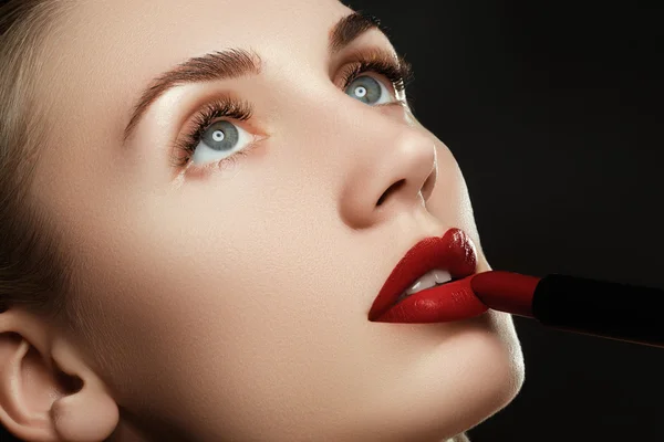 Des lèvres magnifiques. Belles lèvres gros plan, bonne idée pour la publicité des cosmétiques. Modèle appliquant du rouge à lèvres rouge. Maquillage. Maquillage professionnel rétro mode. Rouge à lèvres rouge — Photo