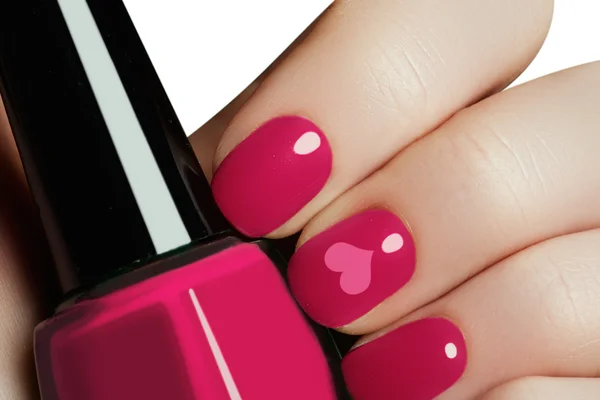 Valentinstag Nail Art Maniküre. Valentinstag Urlaub Stil helle Maniküre mit bemalten Herzen. Flasche Nagellack. Schönheitssalon. Hand. trendige rosa Nägel. Nagellack — Stockfoto