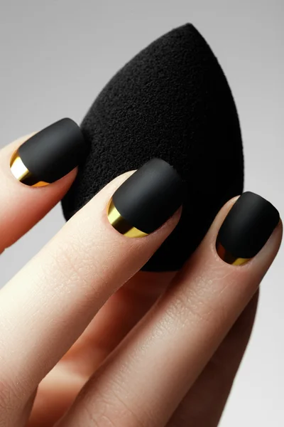 Manicure. Preto esmalte fosco. Unha bem cuidada com esmalte preto fosco. Manicure com esmalte escuro. Manicura de arte de unhas douradas. Estilo de férias manicura brilhante — Fotografia de Stock